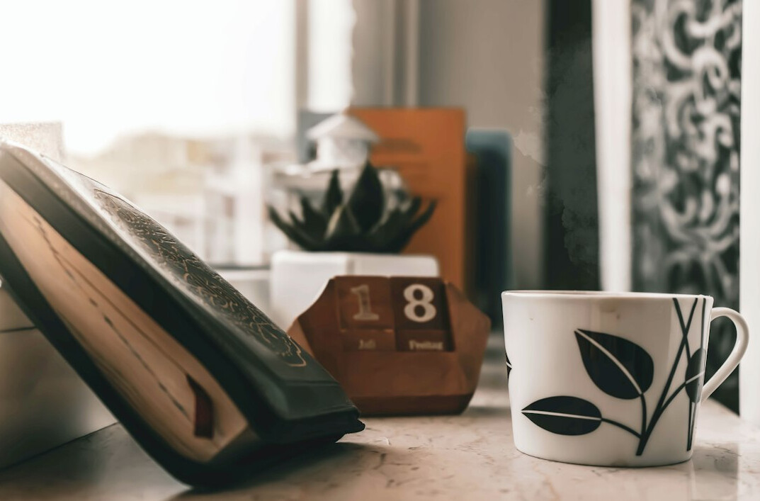 Office desk with a telephone, notebook and pen in natural light